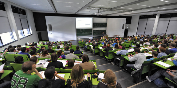 Students sit in a lecture hall in the seminar building at the Campus North.